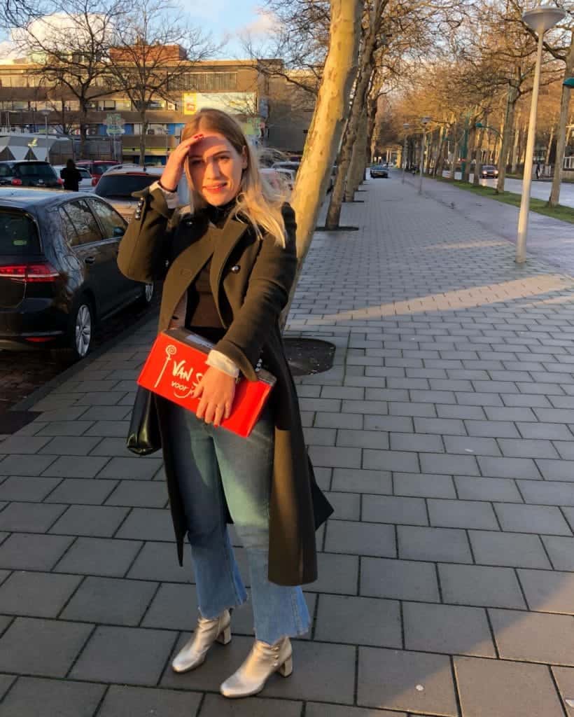 Winter outfit consisting of black turtle neck, jeans, coat and gold boots.