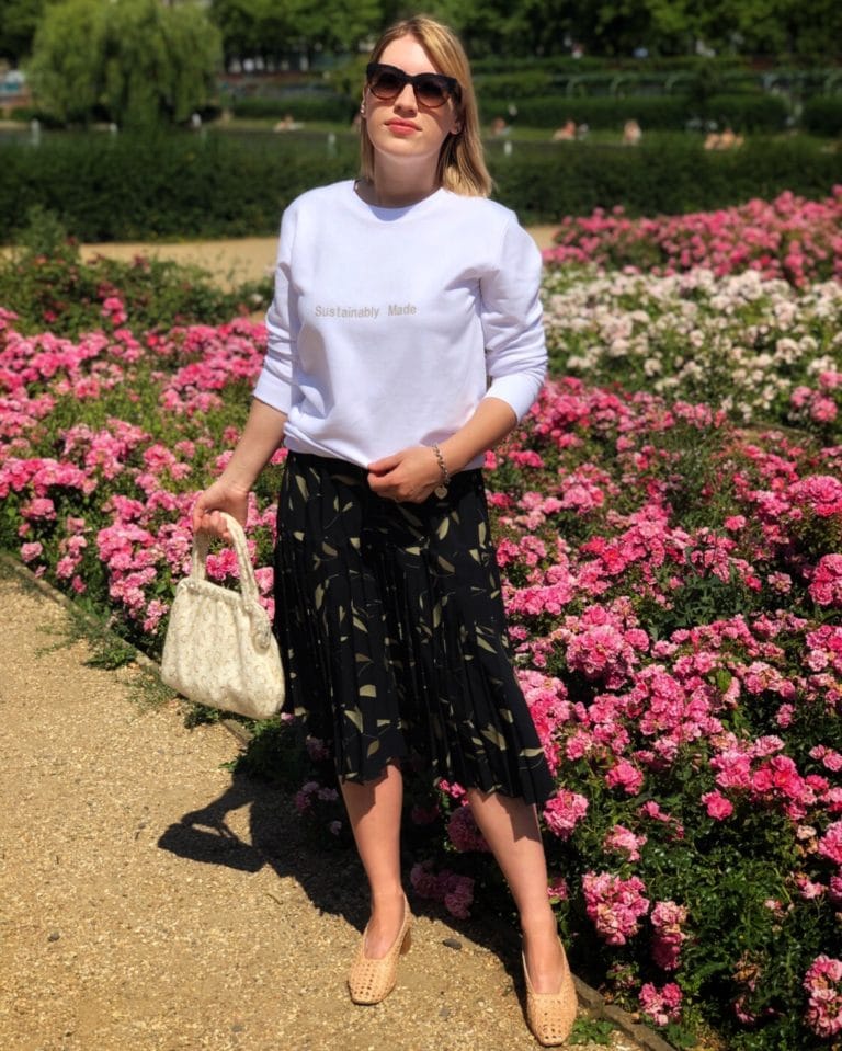 Laura wearing a jumper with the slogan 'sustainably made' along with a vintage skirt and bag.