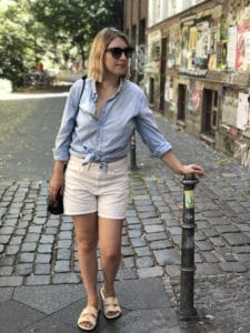 Laura wearing her husbands blue cotton shirt and organic cotton shorts.