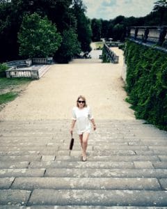 Laura wearing a secondhand blouse walking up garden steps.